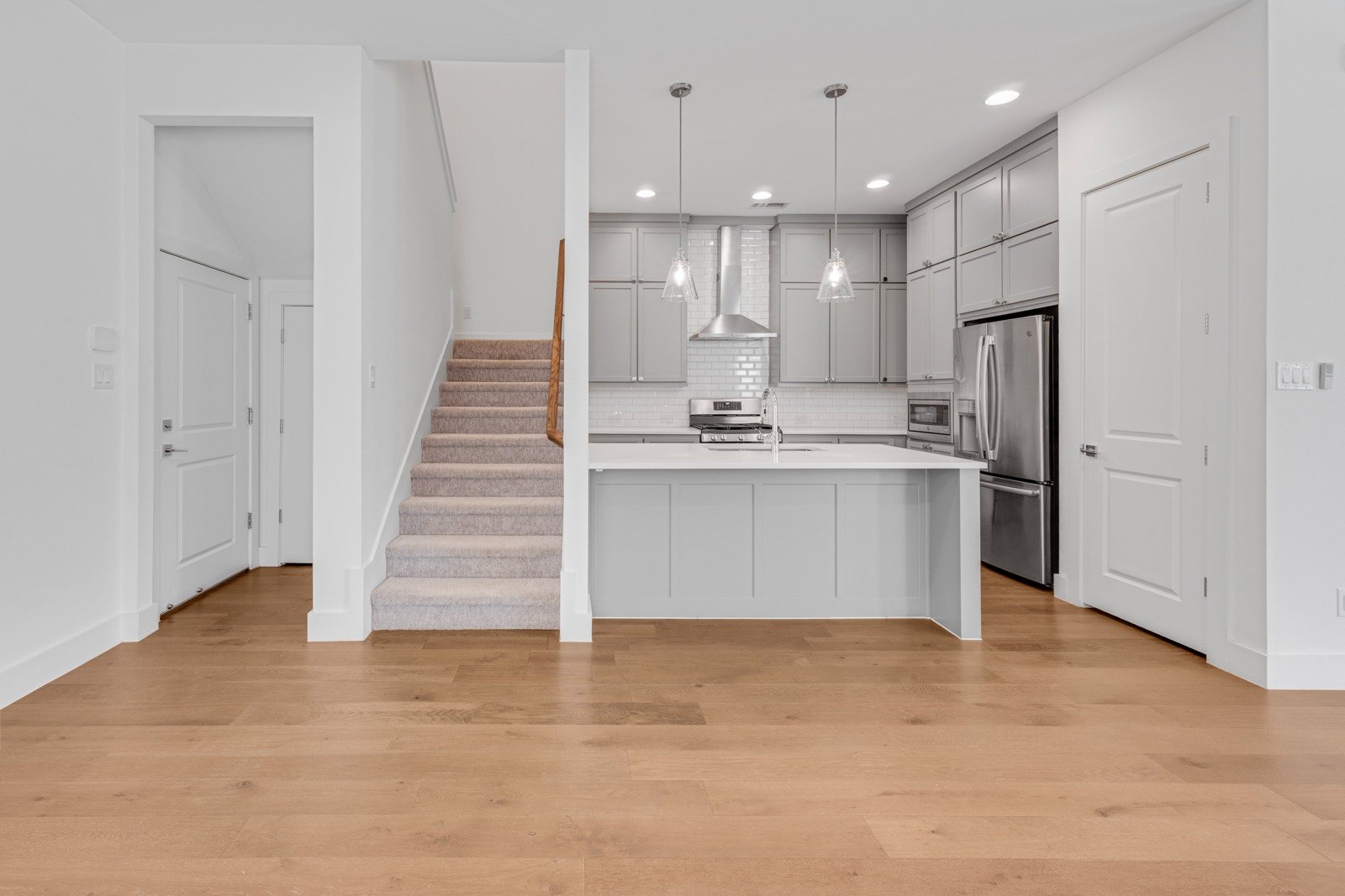 Kitchen and staircase at 2249 Bird St, pendant lights over a white island