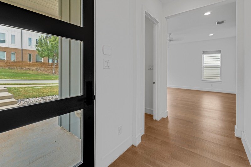 Entry at 2249 Bird St with a tall black-framed window and oak floors